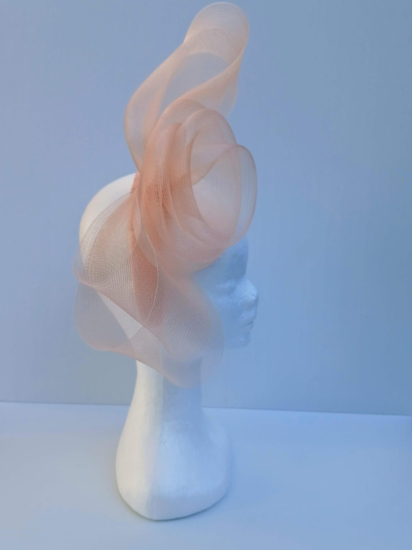 A picture  of an Apricot Crinoline Bow and Rose Headband by Melissa Rath Millinery.