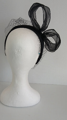 A picture of a  black satin veiled headband by Melissa Rath Millinery.