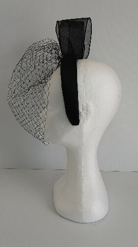A picture of a  black satin veiled headband by Melissa Rath Millinery.