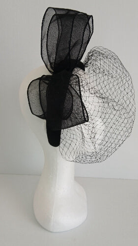 A picture of a  black satin veiled headband by Melissa Rath Millinery.