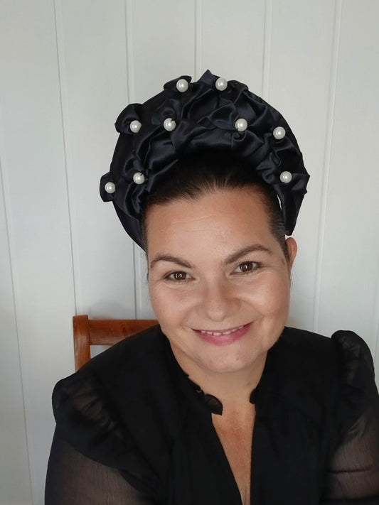 An image of a Black Smocked Satin Crown by Melissa Rath Millinery