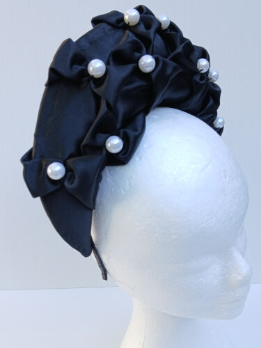 An image of a Black Smocked Satin Crown by Melissa Rath Millinery