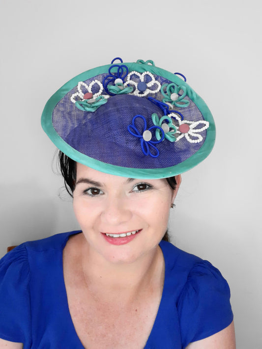 A  picture of a Blue and Green Saucer Hat by Melissa Rath Millinery.