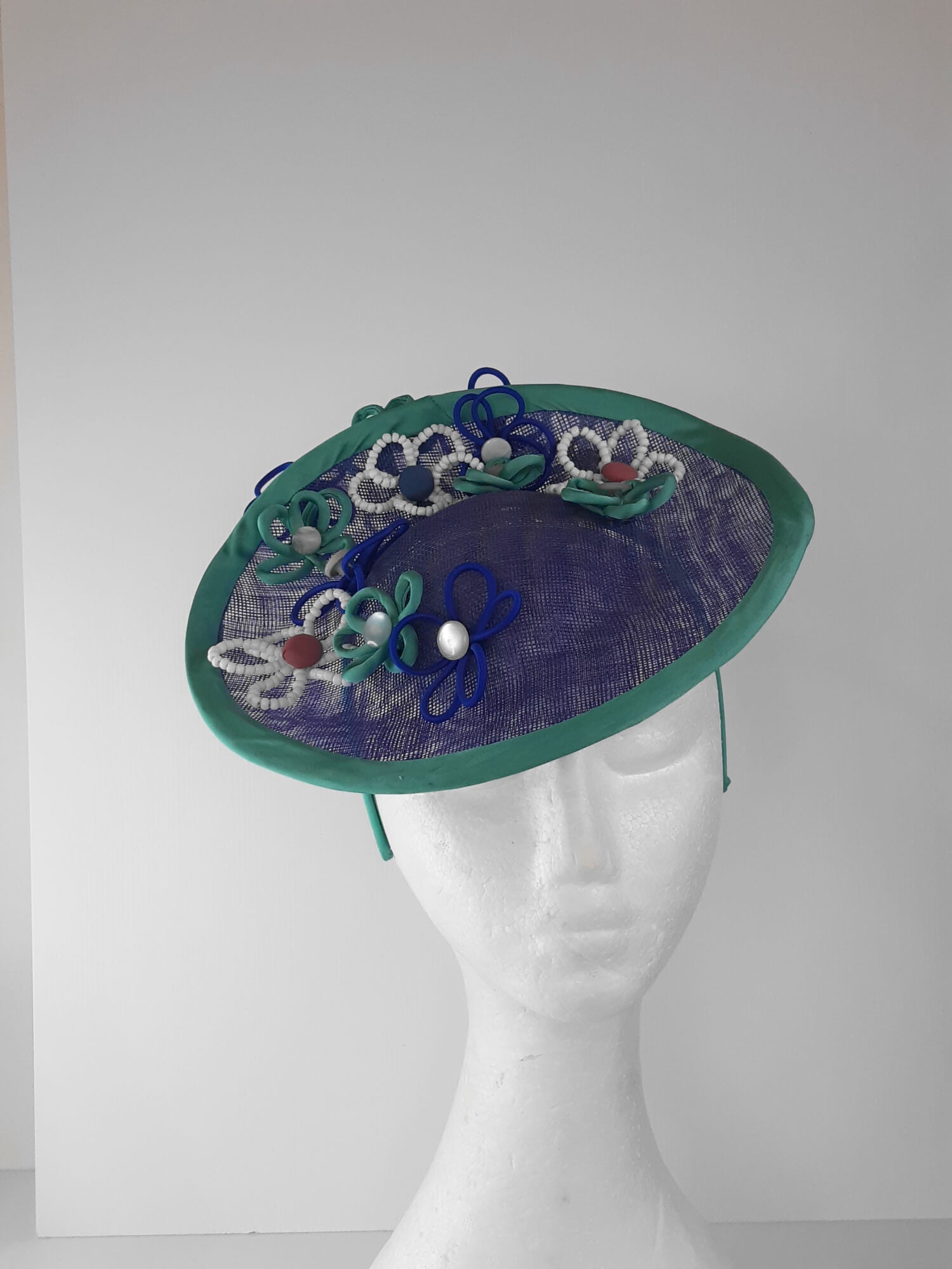 A picture of a Blue and Green Saucer Hat by Melissa Rath Millinery.