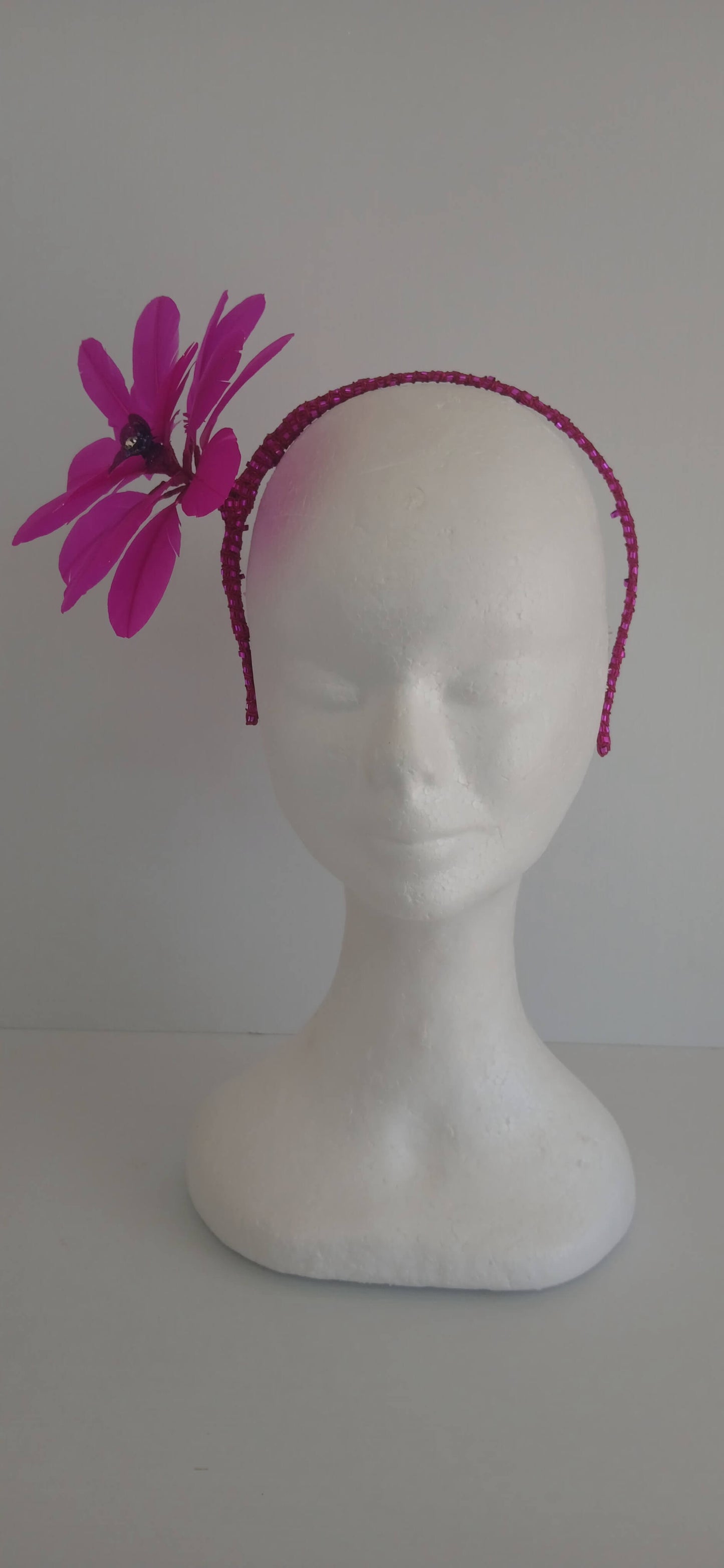 An image of the Bright Pink Feather Flower Headband by Melissa Rath Millinery