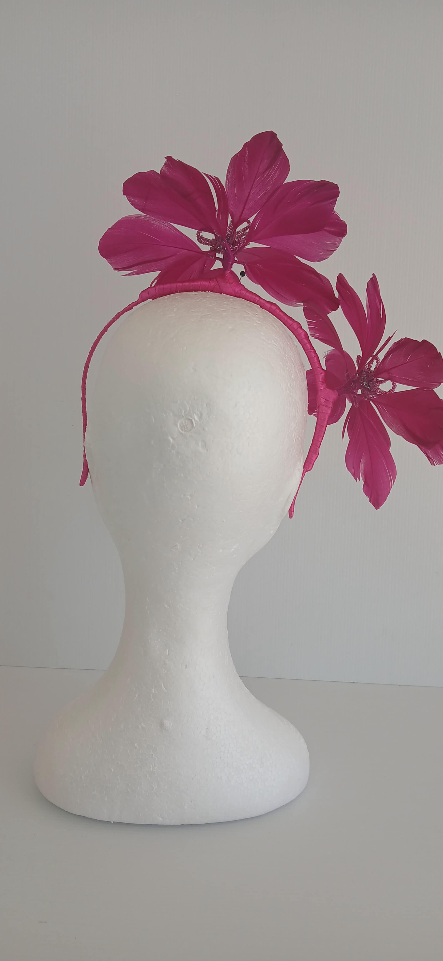 An image of the Dark Pink Feather Flower Headband by Melissa Rath Millinery