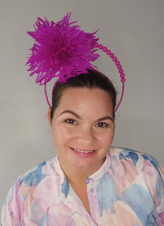 A picture of a Pink Halo Beaded Headband with feather flower by Melissa Rath Millinery.