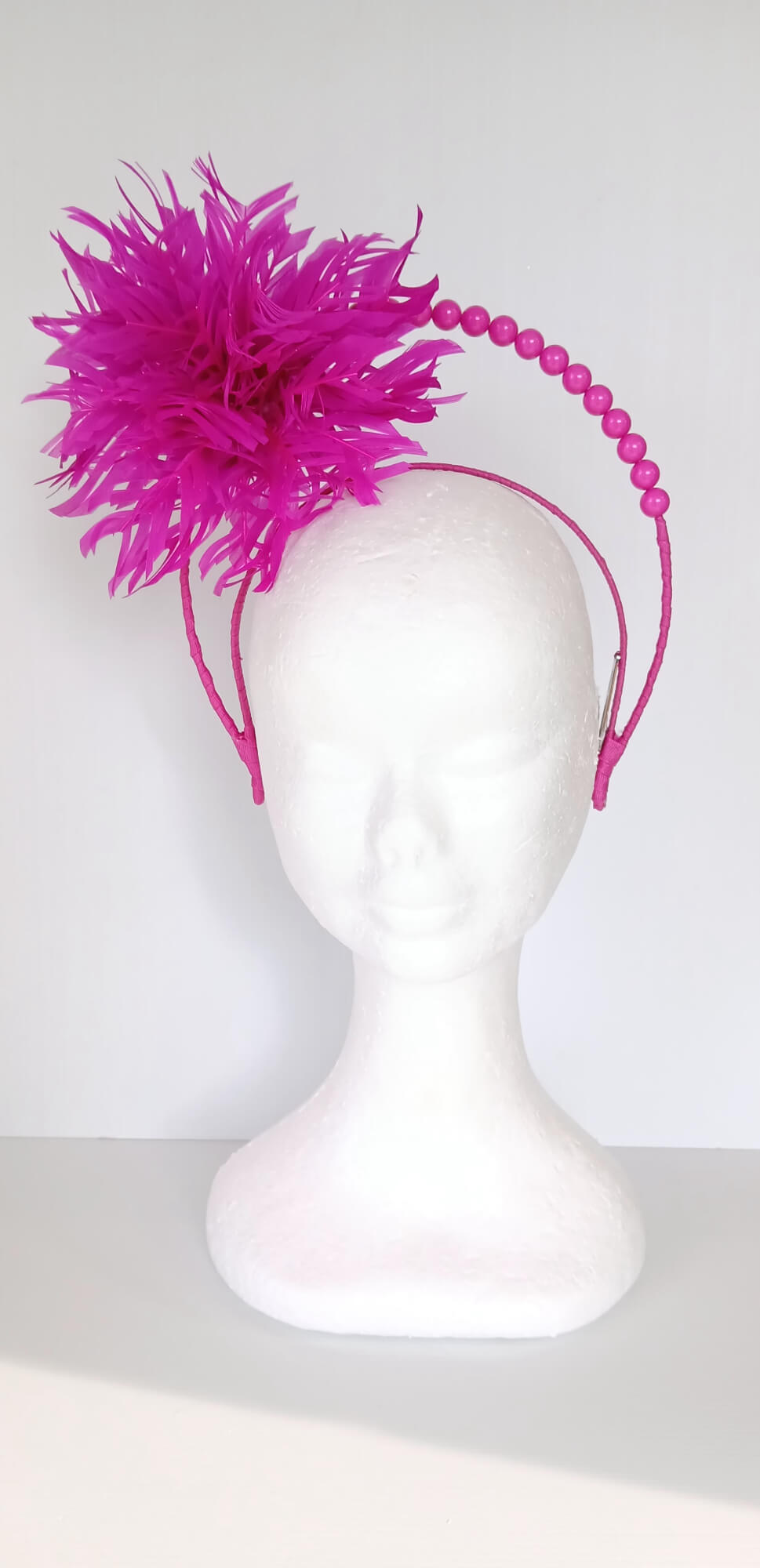 A picture of a Pink Halo Beaded Headband with feather flower by Melissa Rath Millinery.
