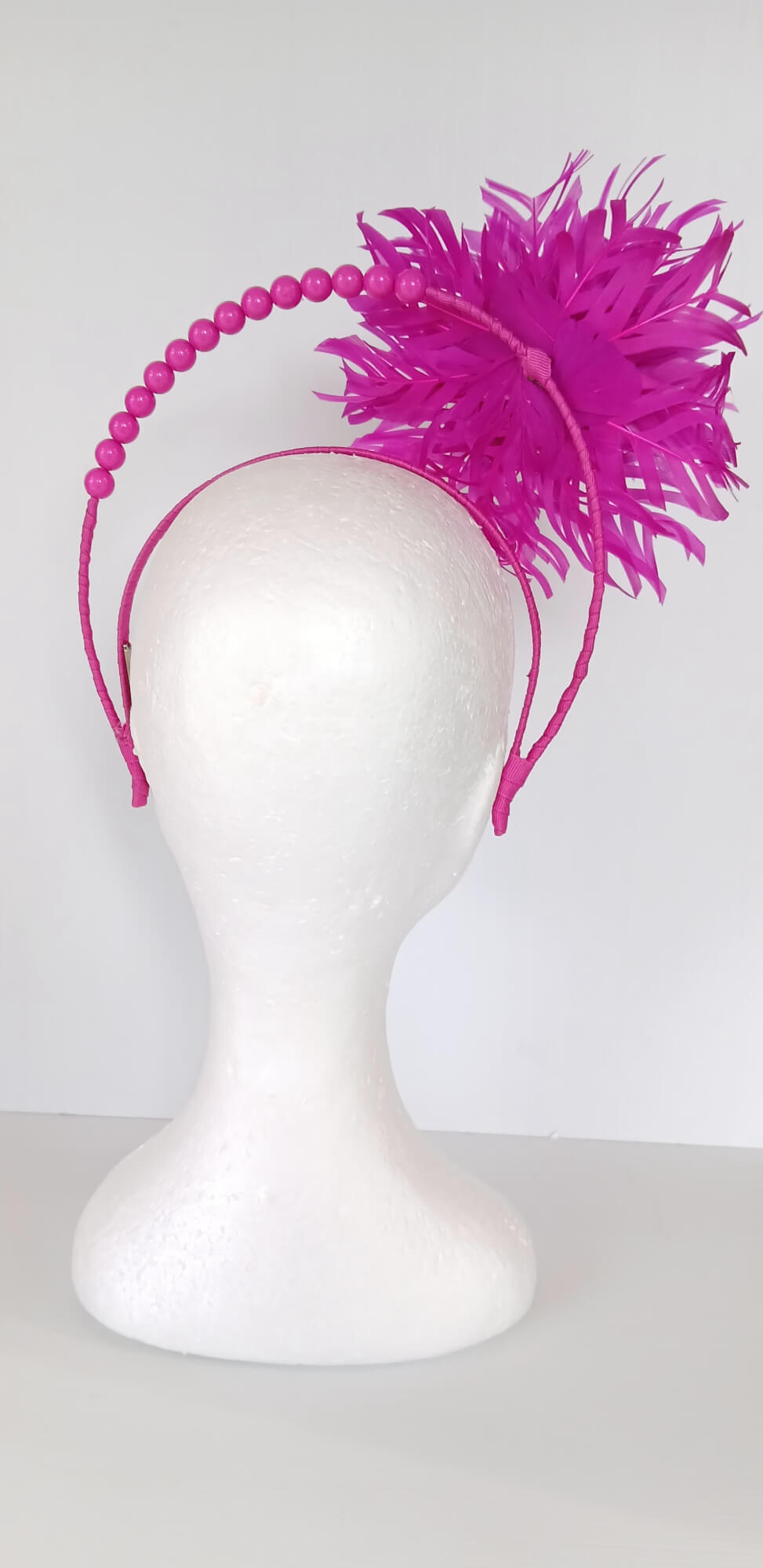 A picture of a Pink Halo Beaded Headband with feather flower by Melissa Rath Millinery.