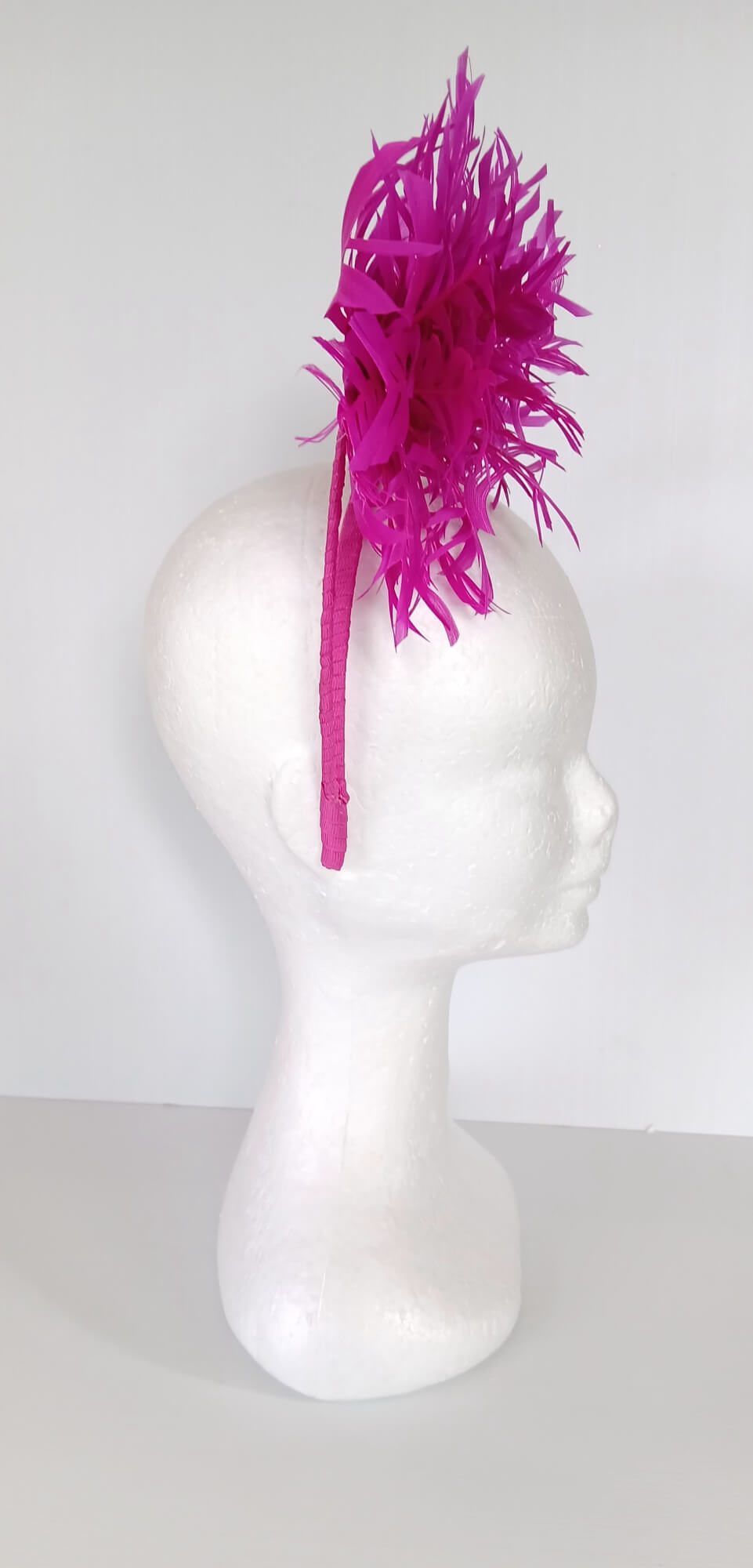 A picture of a Pink Halo Beaded Headband with feather flower by Melissa Rath Millinery.