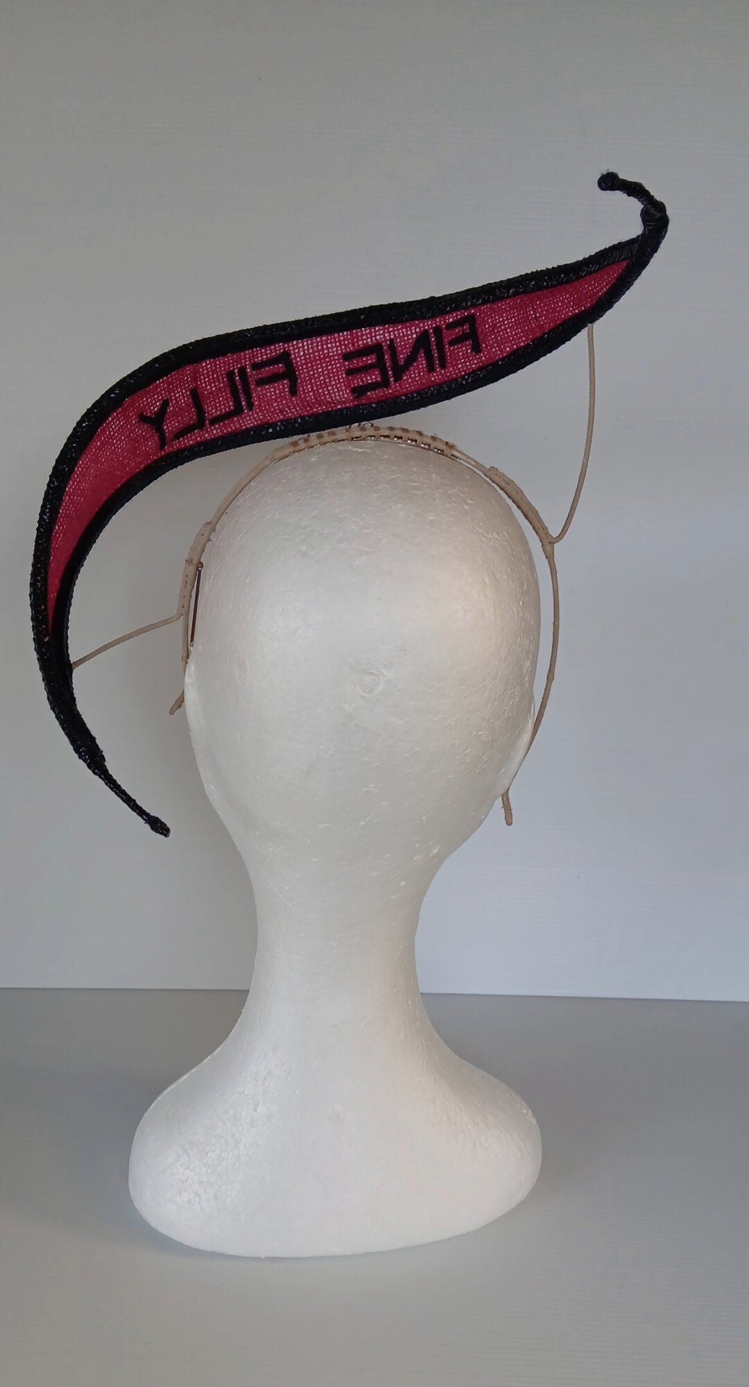 A picture of a Pink and Navy Floating Headpiece by Melissa Rath Millinery.
