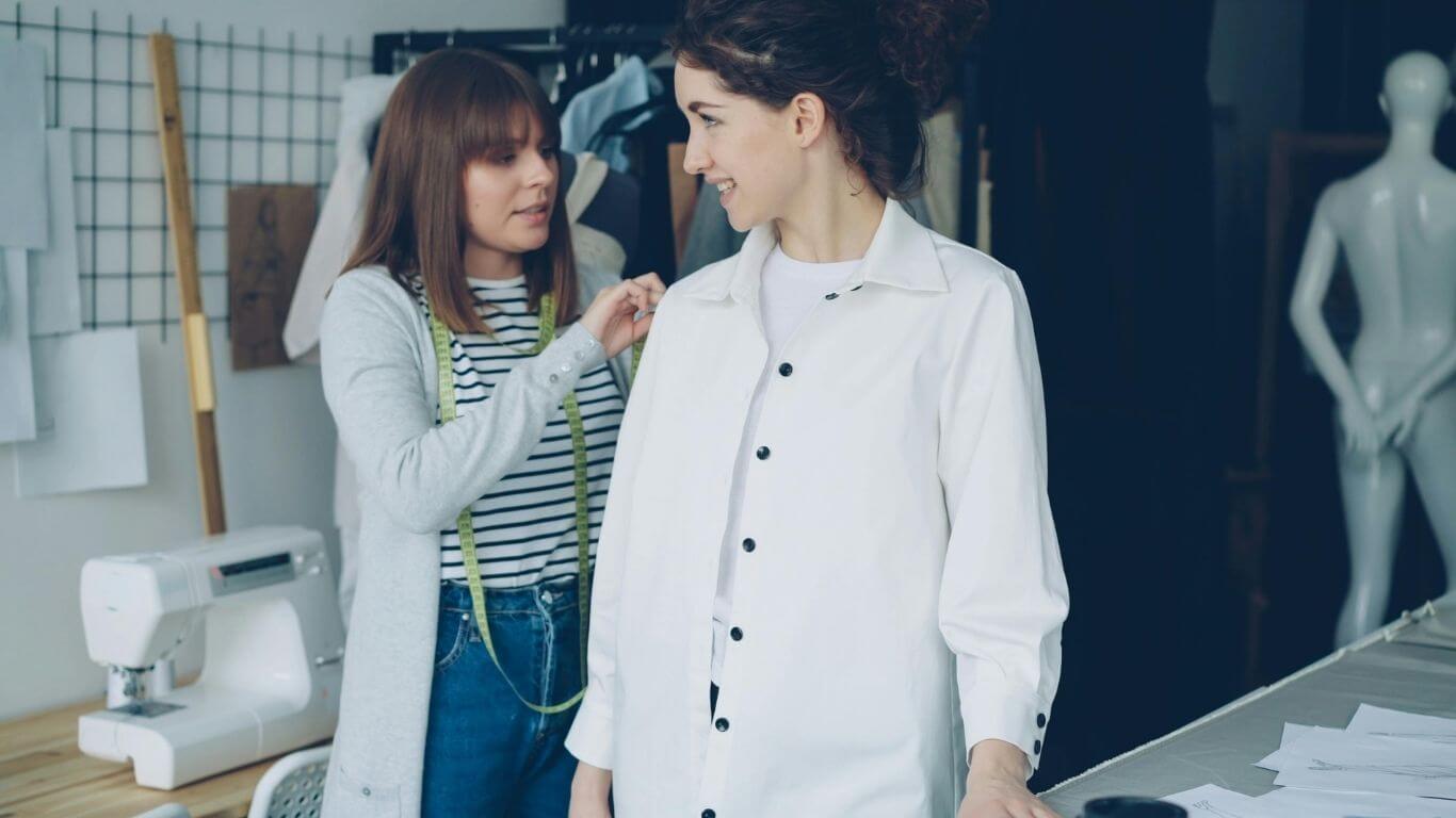 An image of someone doing a fitting on a clothing model.