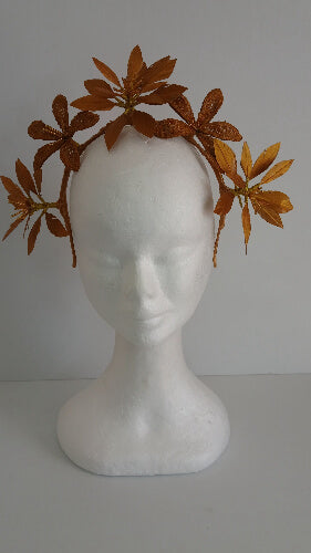 A picture of a gold feather flower headband by Melissa Rath Millinery.