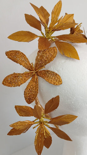A picture of a gold feather flower headband by Melissa Rath Millinery.