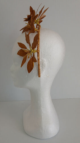 A picture of a gold feather flower headband by Melissa Rath Millinery.