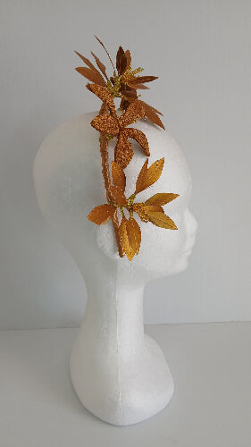A picture of a gold feather flower headband by Melissa Rath Millinery.