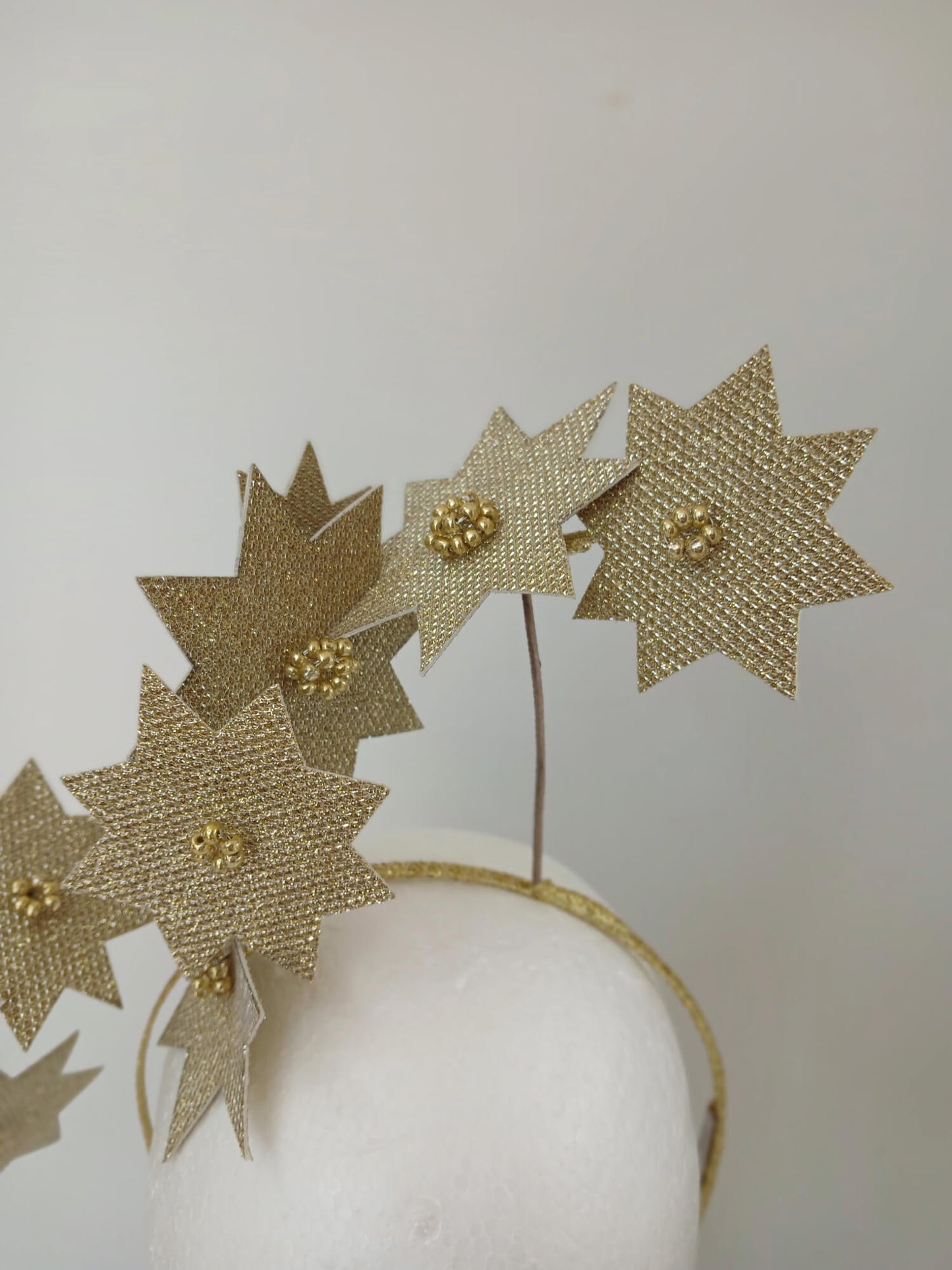 A picture of a Gold Pleather Millinery Fascinator by Melissa Rath Millinery