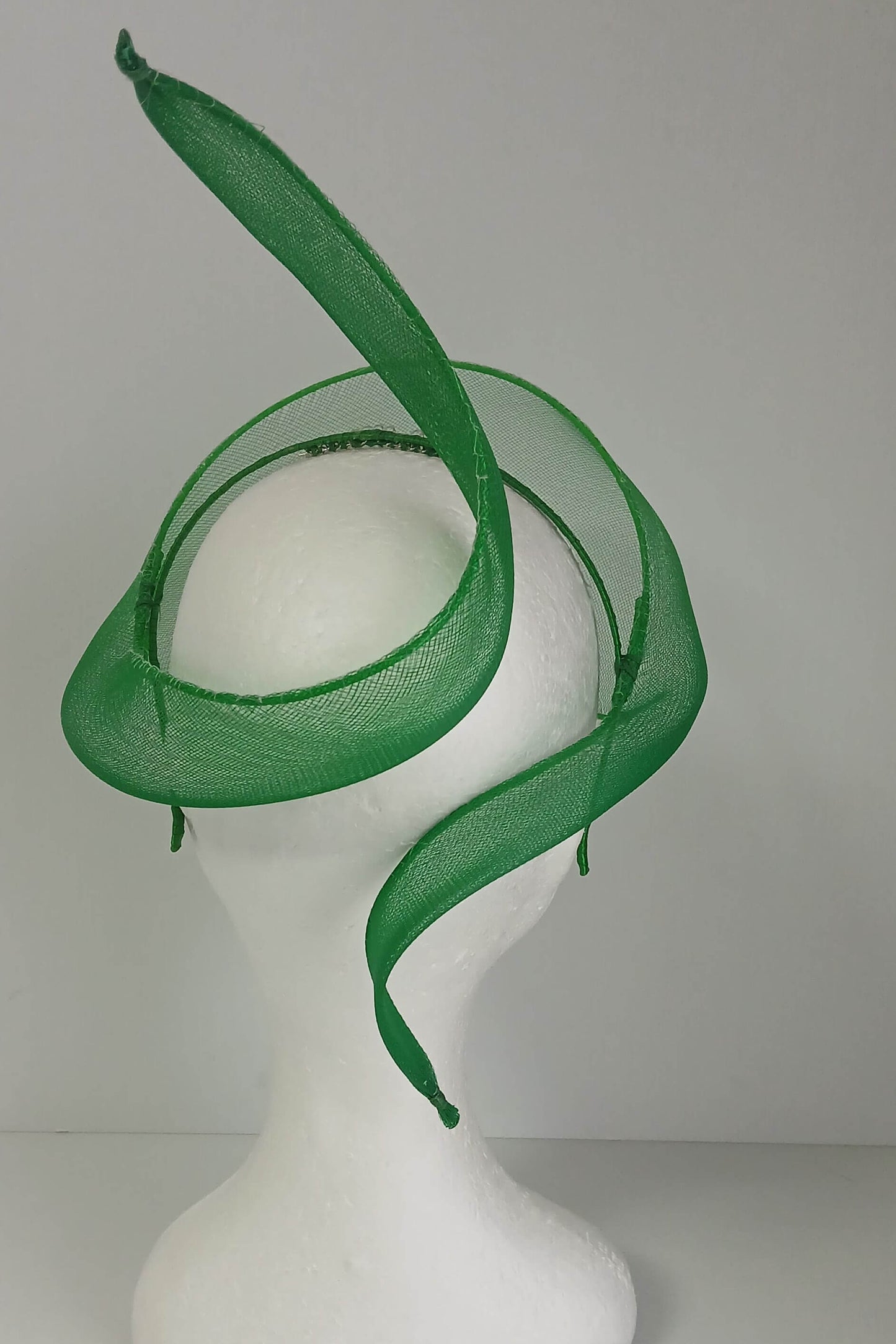 A picture of a green crinoline veil with Swirls by Melissa Rath Millinery
