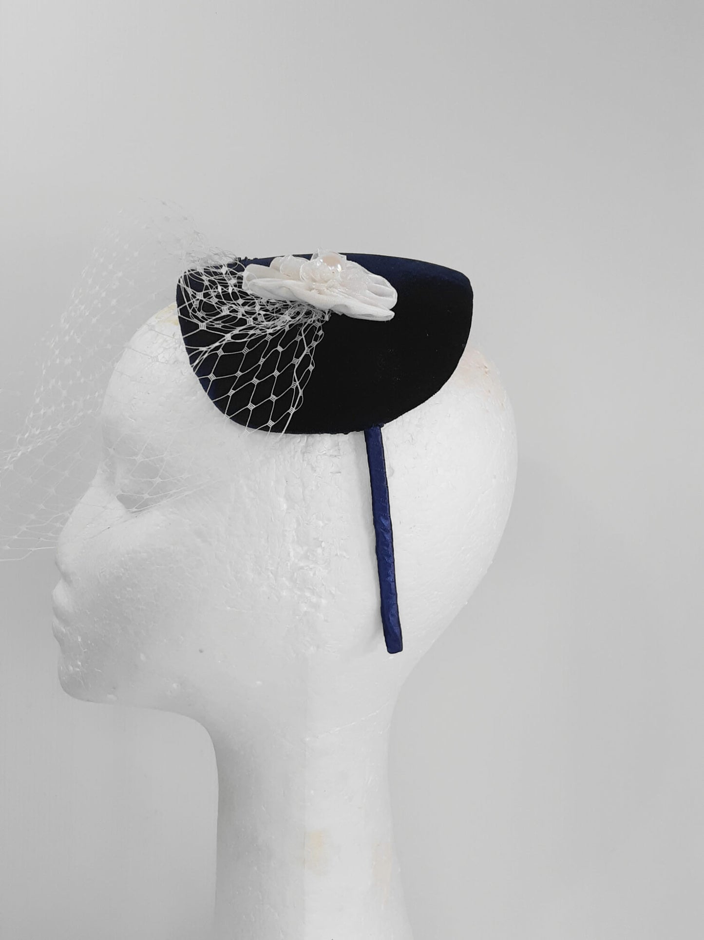 A picture of a Navy and White Veiled Velvet Millinery Fascinator by Melissa Rath Millinery.