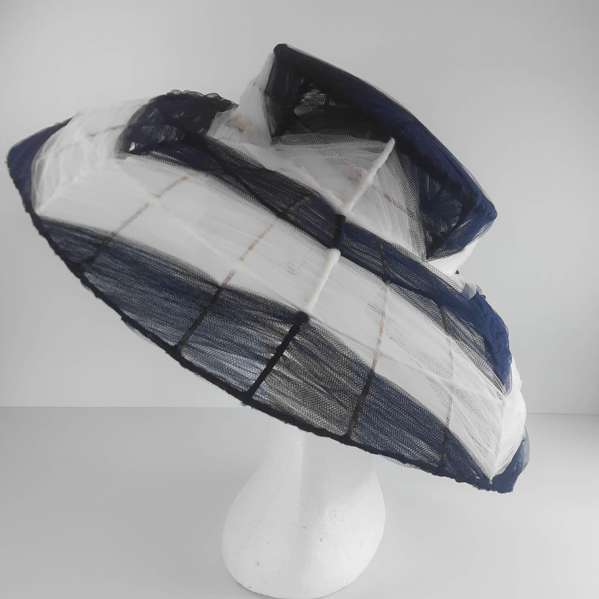 A picture of a navy and white wire and tulle millinery hat by Melissa Rath Millinery.