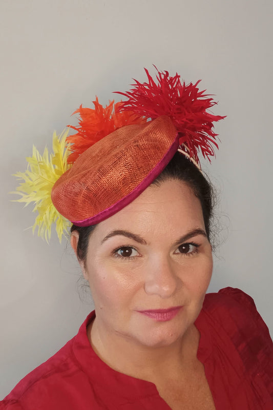 A picture of an Orange, Red and Yellow Millinery Pillbox Hat by Melissa Rath Millinery.