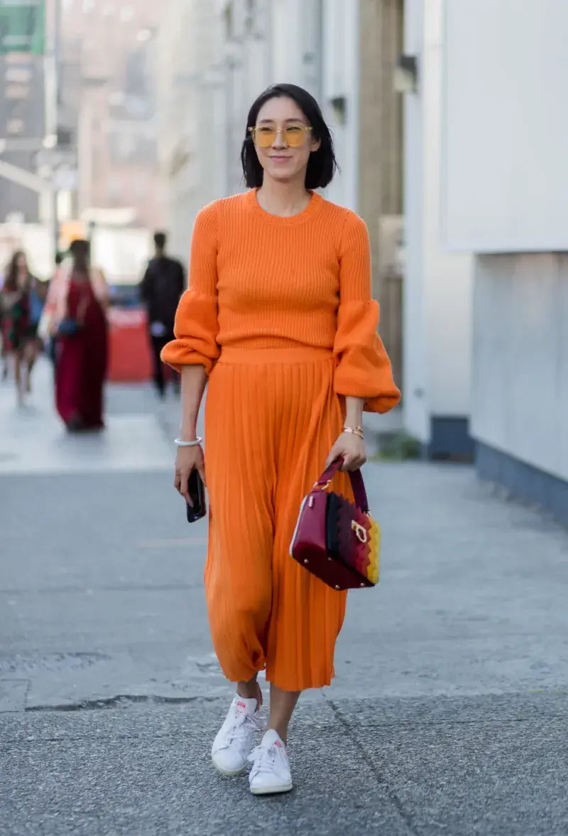 A picture of a woman wearing an outfit in an orange monochromatic colour scheme.