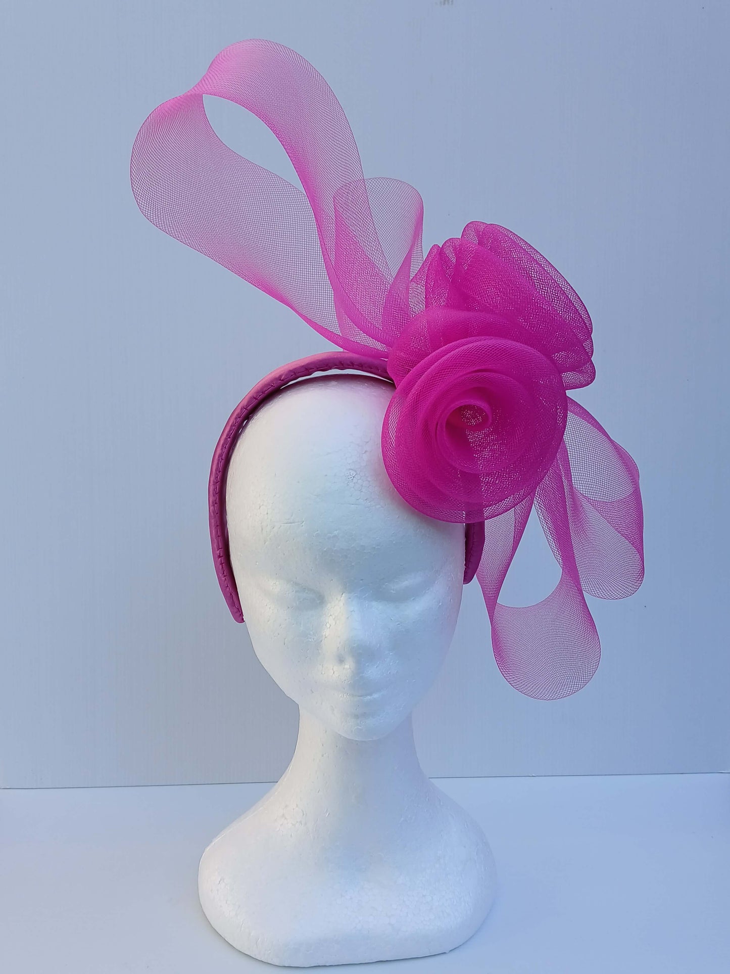 An image of aPink Crinoline Bow and Rose Headband by Melissa Rath Millinery