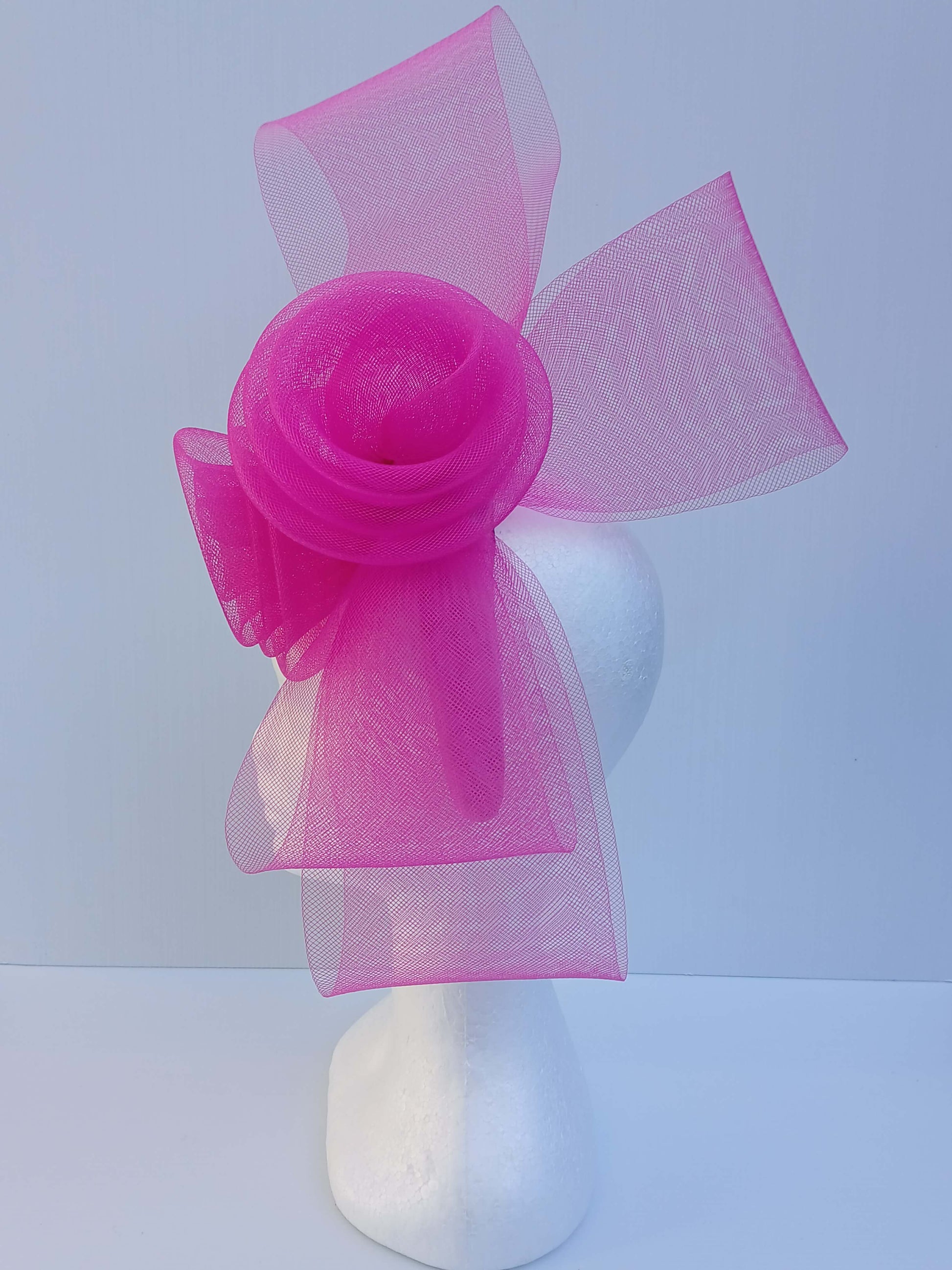 A picture of a Pink Crinoline Bow and Rose Headband by Melissa Rath Millinery