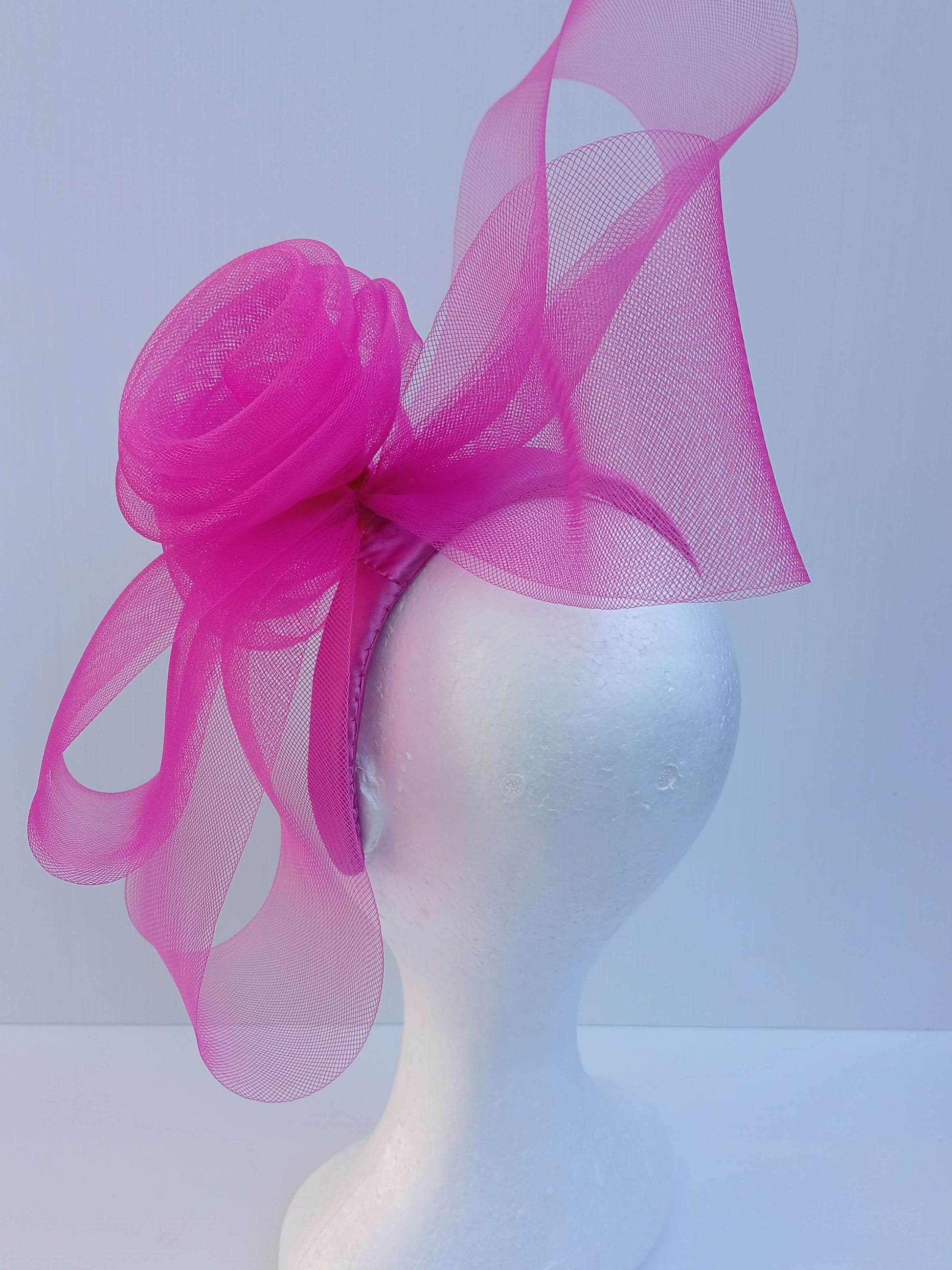 A picture of a Pink Crinoline Bow and Rose Headband by Melissa Rath Millinery