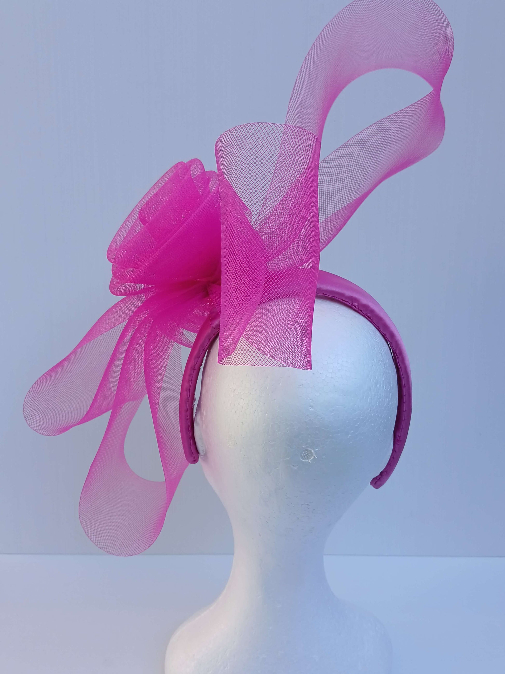 A picture of a Pink Crinoline Bow and Rose Headband by Melissa Rath Millinery