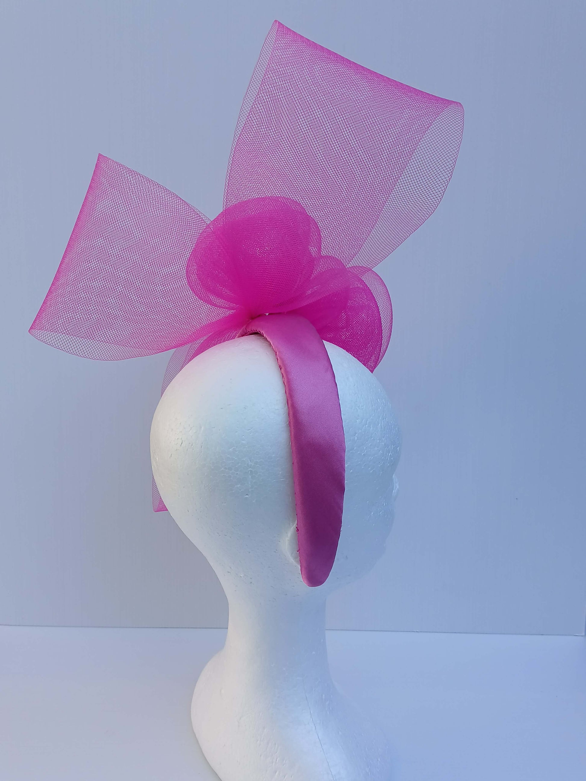 A picture of a Pink Crinoline Bow and Rose Headband by Melissa Rath Millinery