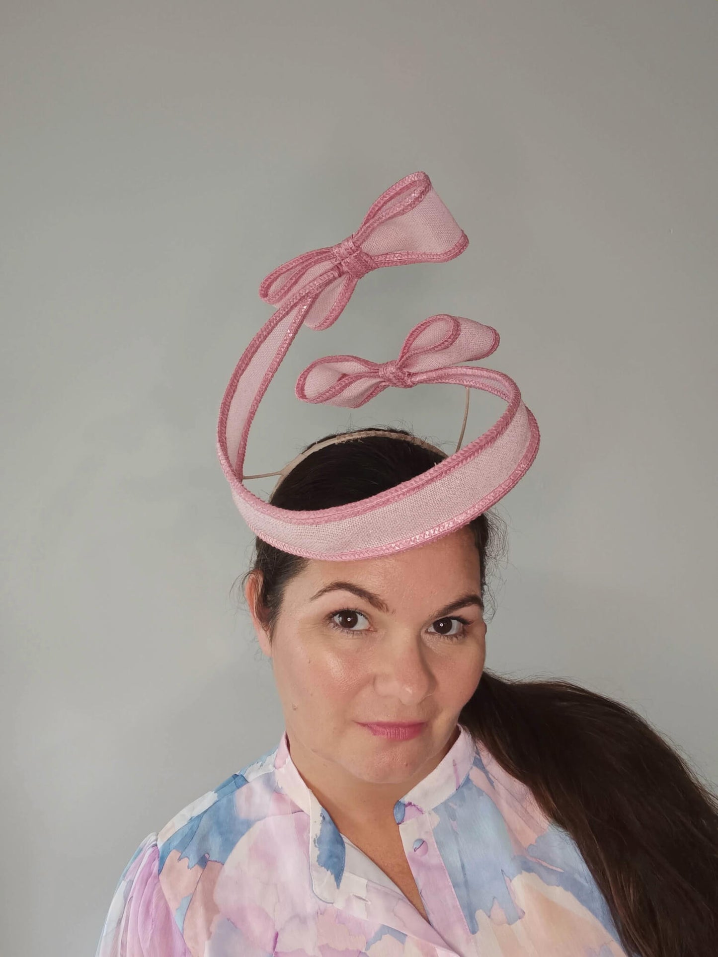A picture of a Pink Bow Floating Headpiece by Melissa Rath Millinery