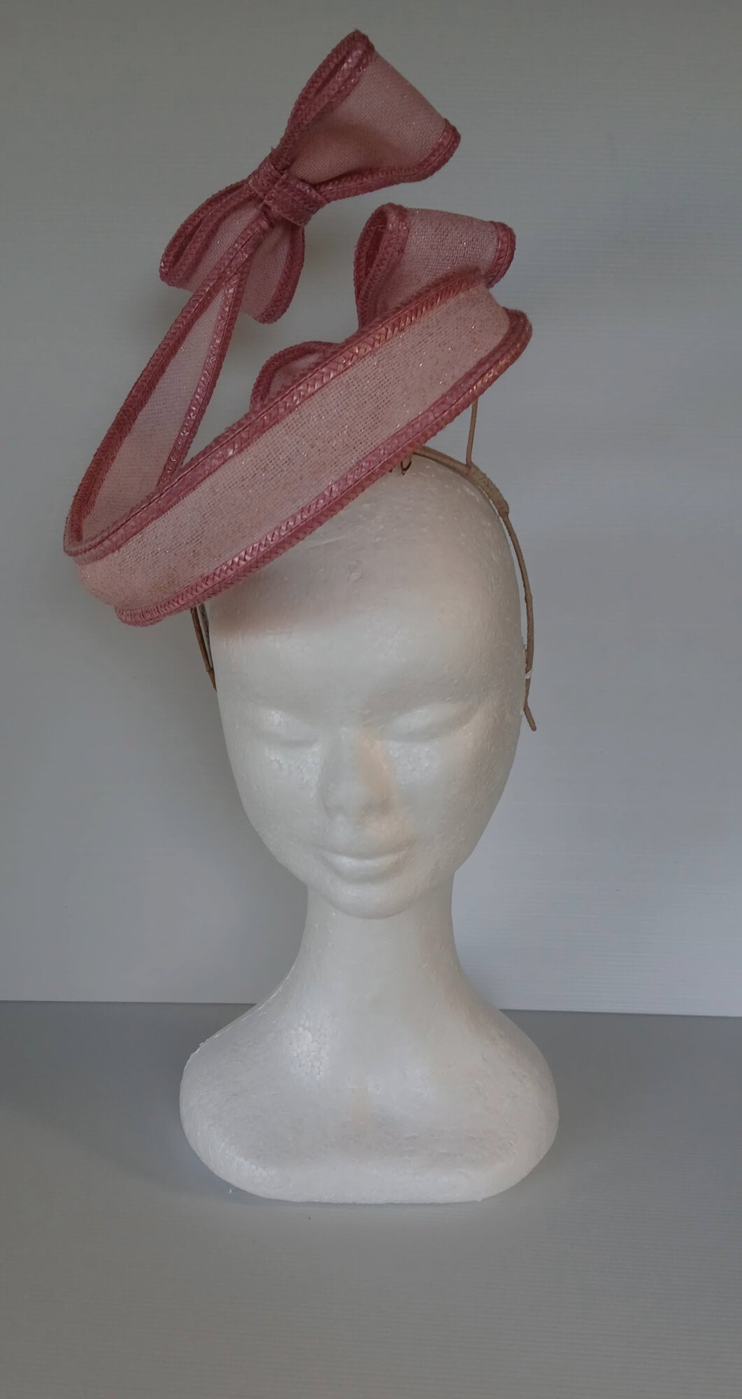 A picture of a Pink Bow Floating Headpiece by Melissa Rath Millinery