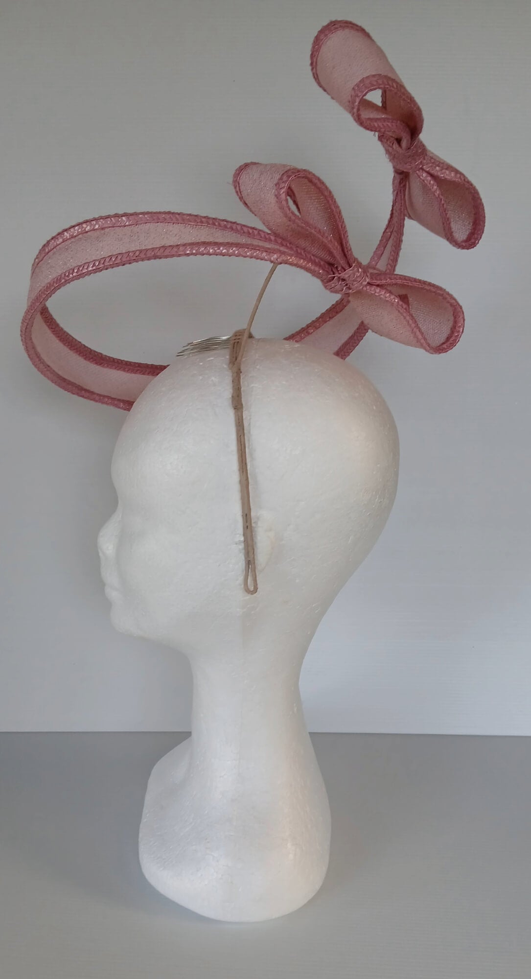 A picture of a Pink Bow Floating Headpiece by Melissa Rath Millinery
