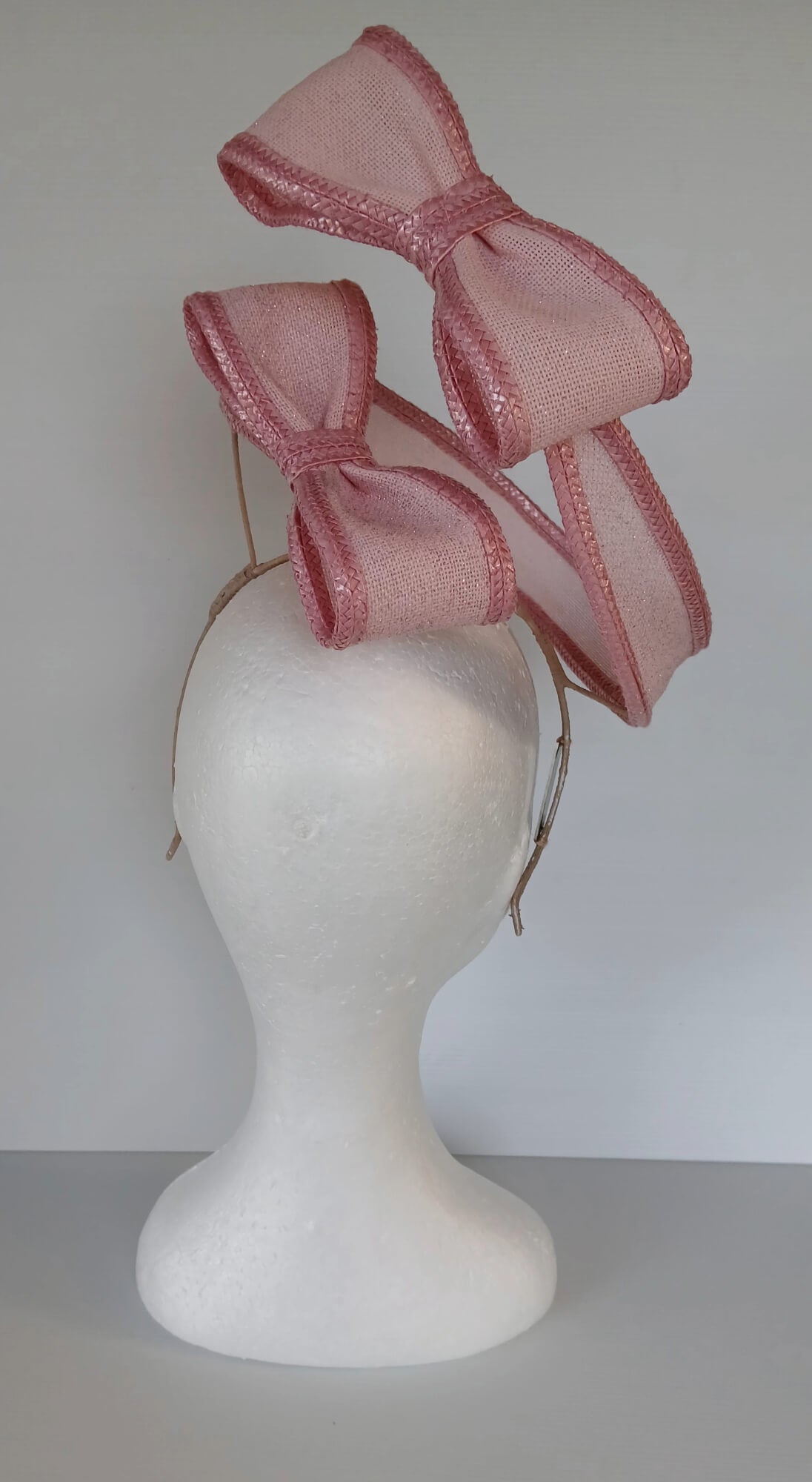 A picture of a Pink Bow Floating Headpiece by Melissa Rath Millinery