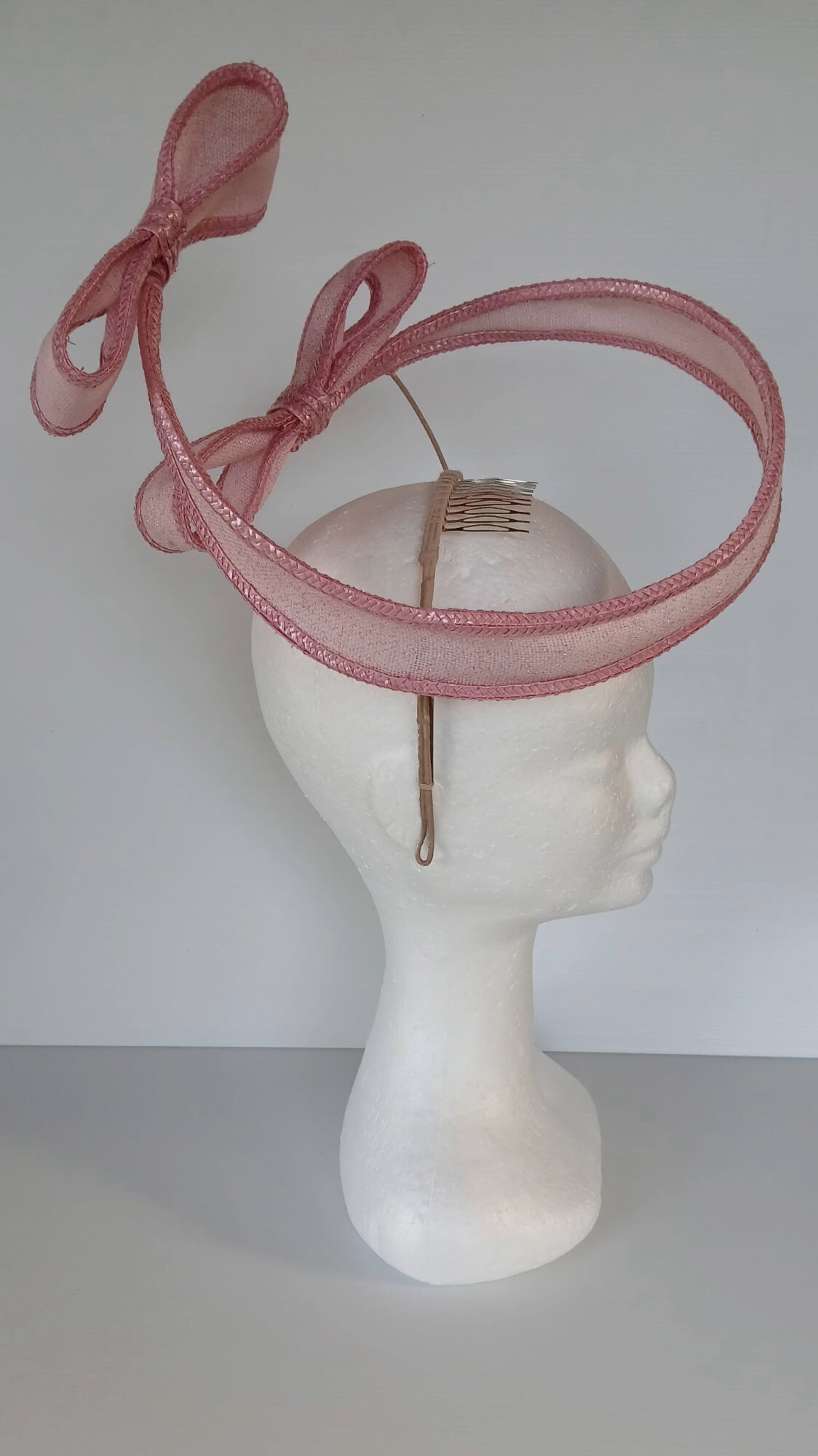 A picture of a Pink Bow Floating Headpiece by Melissa Rath Millinery