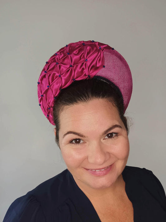 A picture of a Pink Smocked Millinery Crown by Melissa Rath Millinery. 