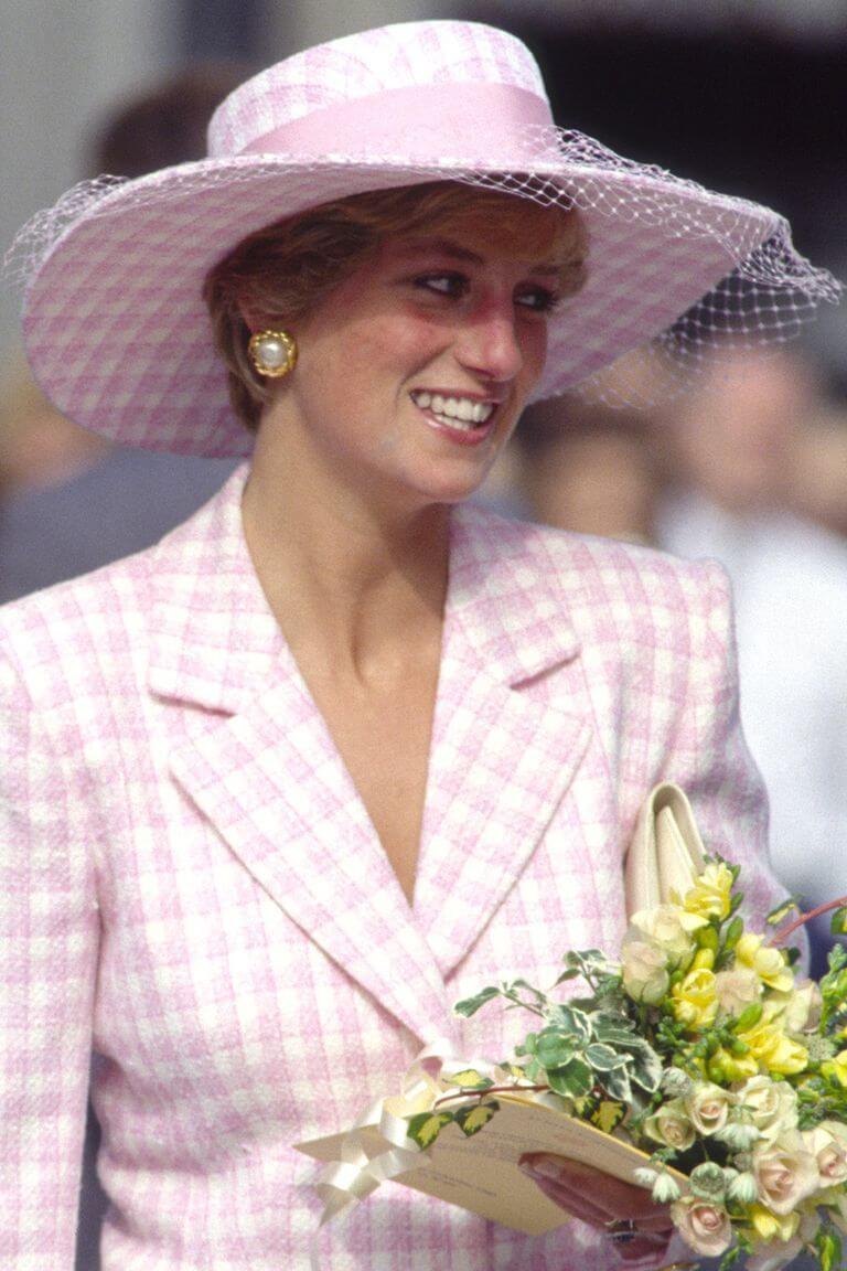 A picture of Princess Diana in a Pink Suit and matching wide brim hat.