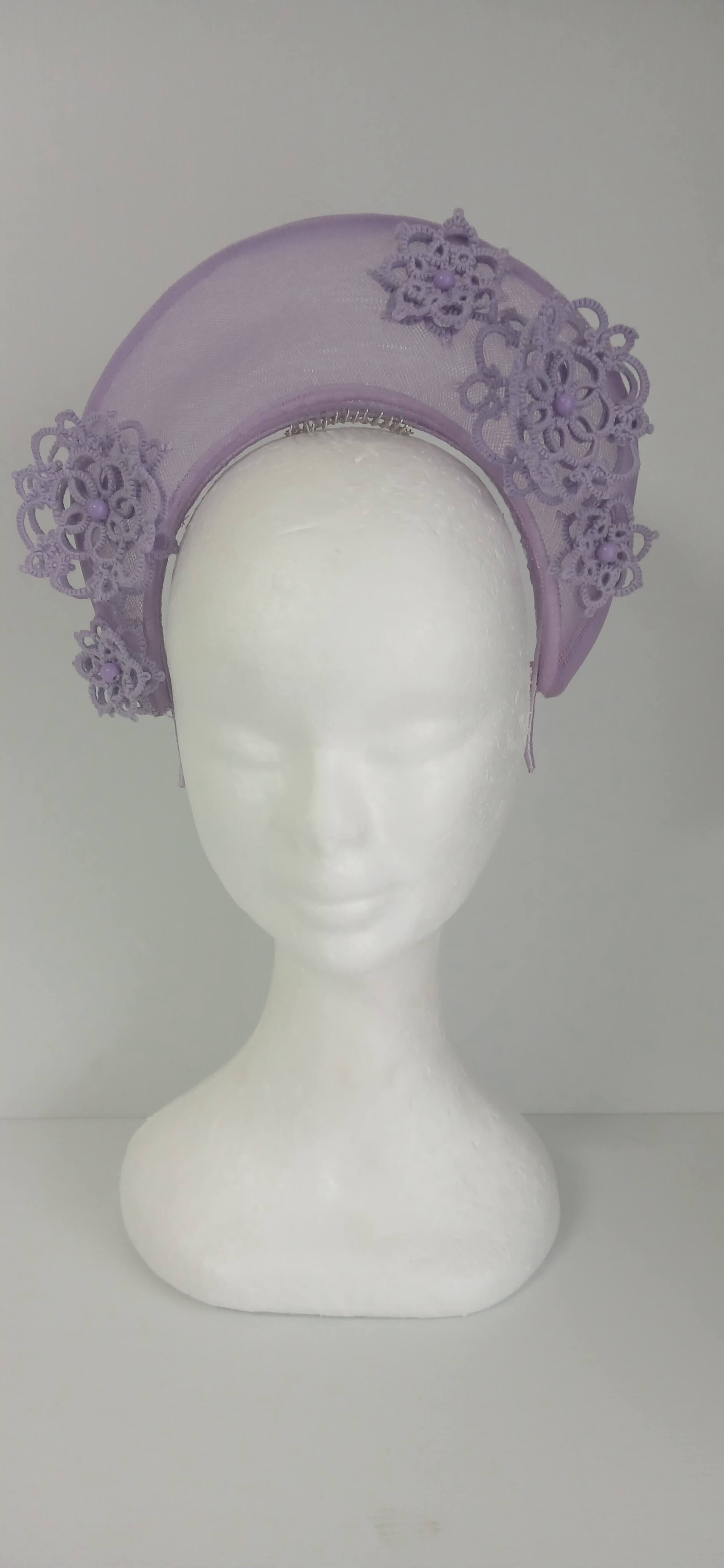 A lavender purple millinery crown by Melissa Rath Millinery, made from crinoline and trimmer with hand tatted flowers.