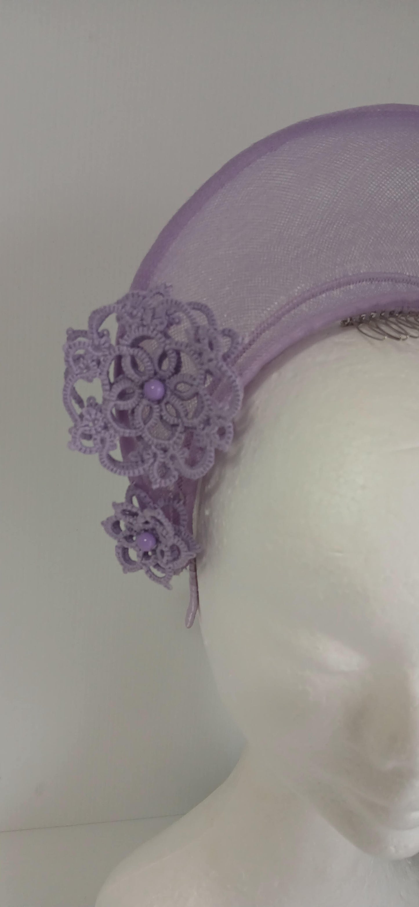 A lavender purple millinery crown by Melissa Rath Millinery, made from crinoline and trimmer with hand tatted flowers.