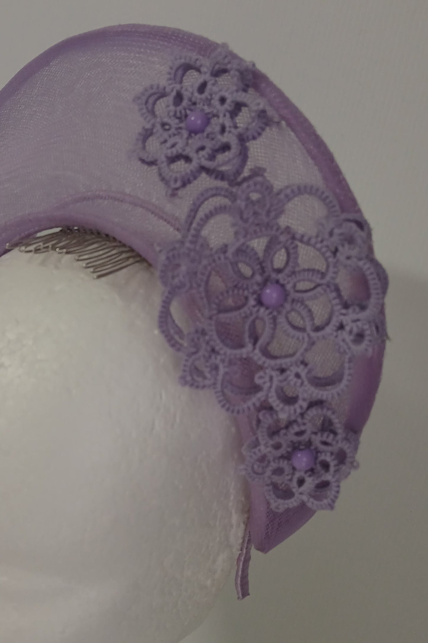 A lavender purple millinery crown by Melissa Rath Millinery, made from crinoline and trimmer with hand tatted flowers.
