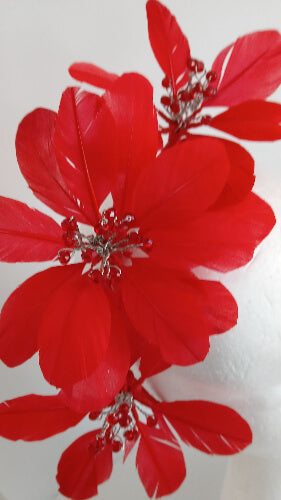 A picture of a red feather flower millinery headband by Melissa Rath iillinery.