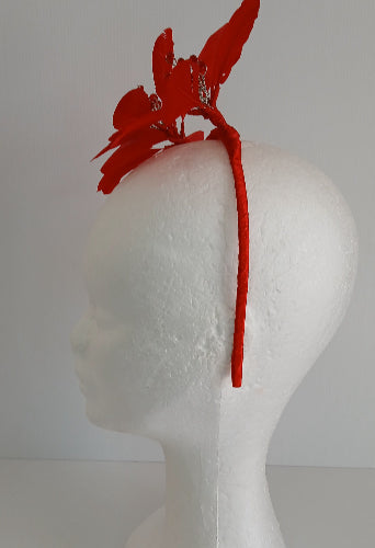 A picture of a red feather flower millinery headband by Melissa Rath iillinery.
