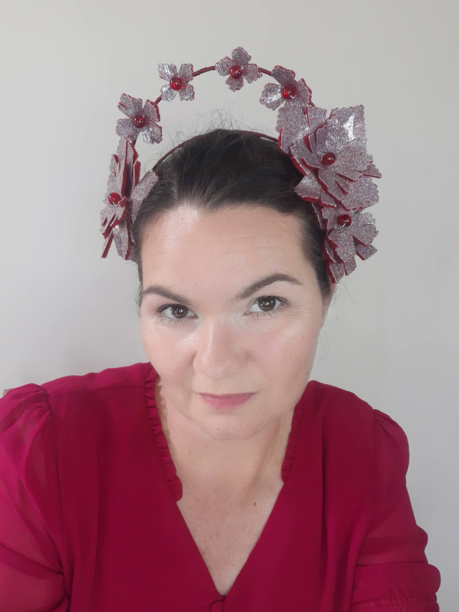 A picture of a red millinery crown halo by Melissa Rath Millinery.