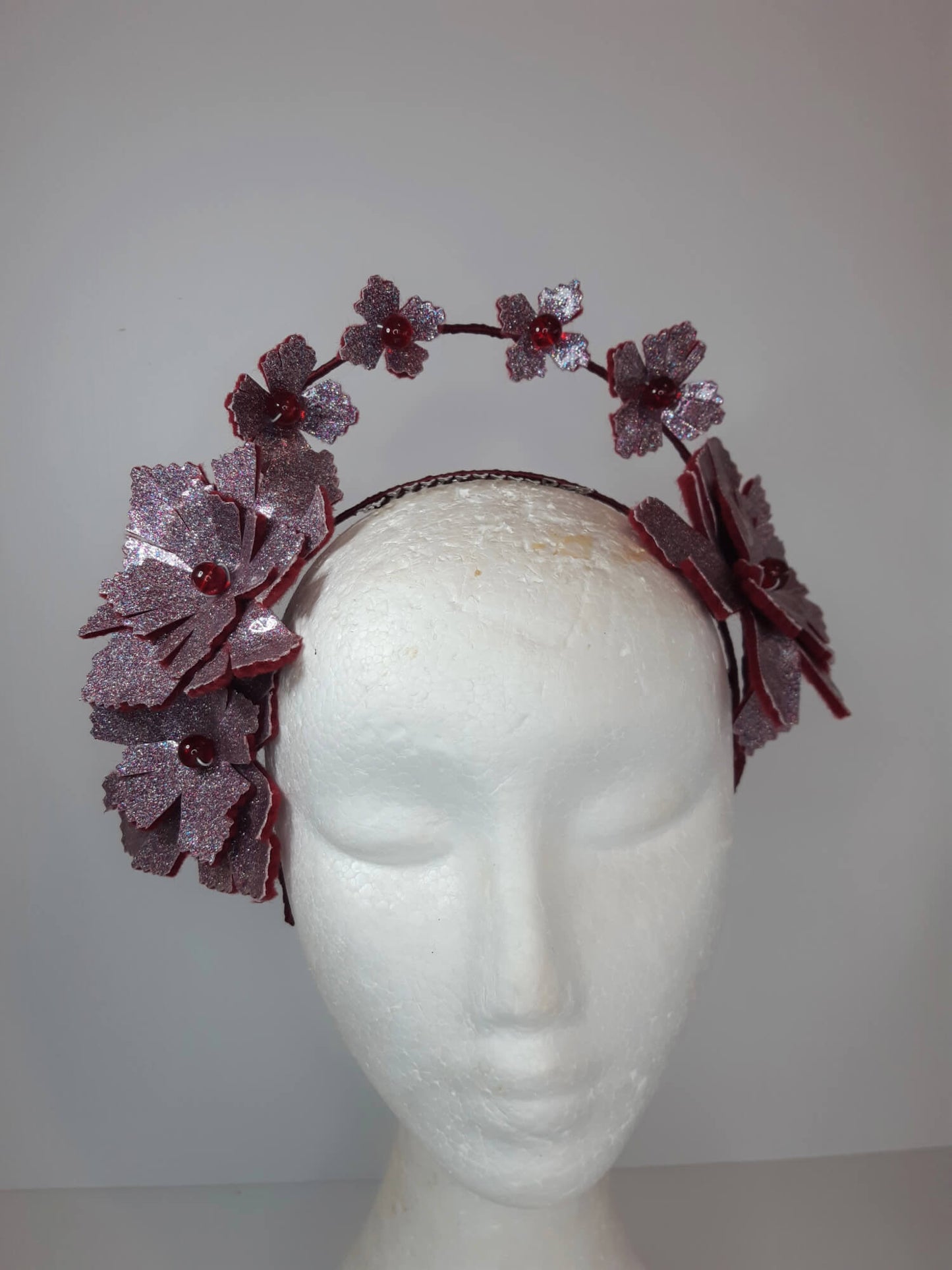 A picture of a red millinery crown halo by Melissa Rath Millinery.