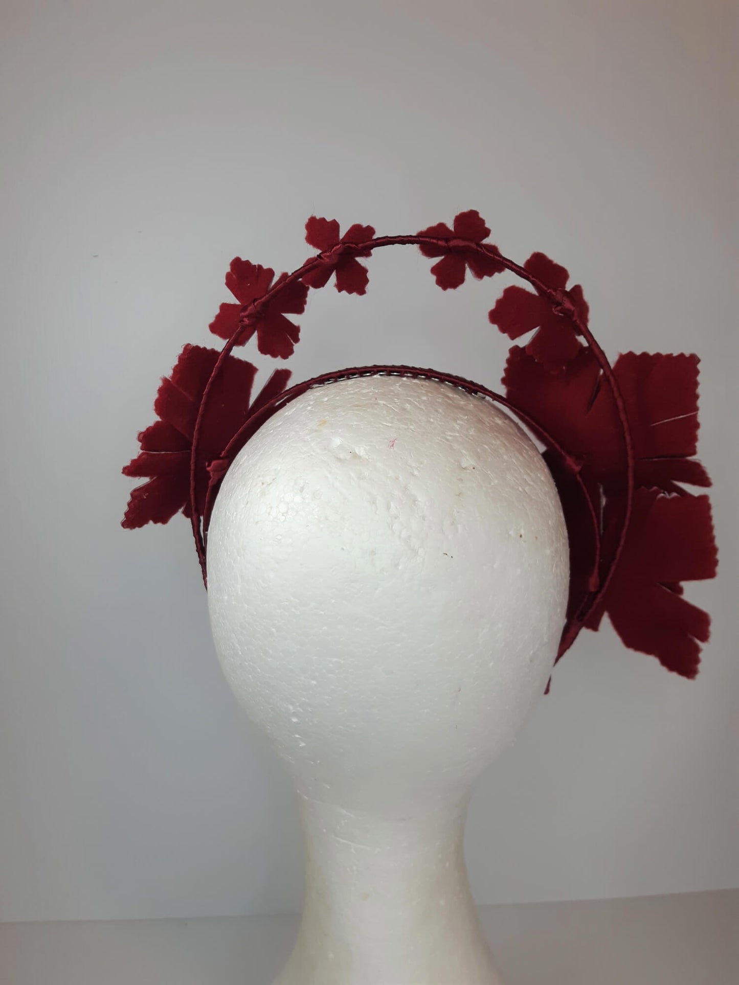 A picture of a red millinery crown halo by Melissa Rath Millinery.