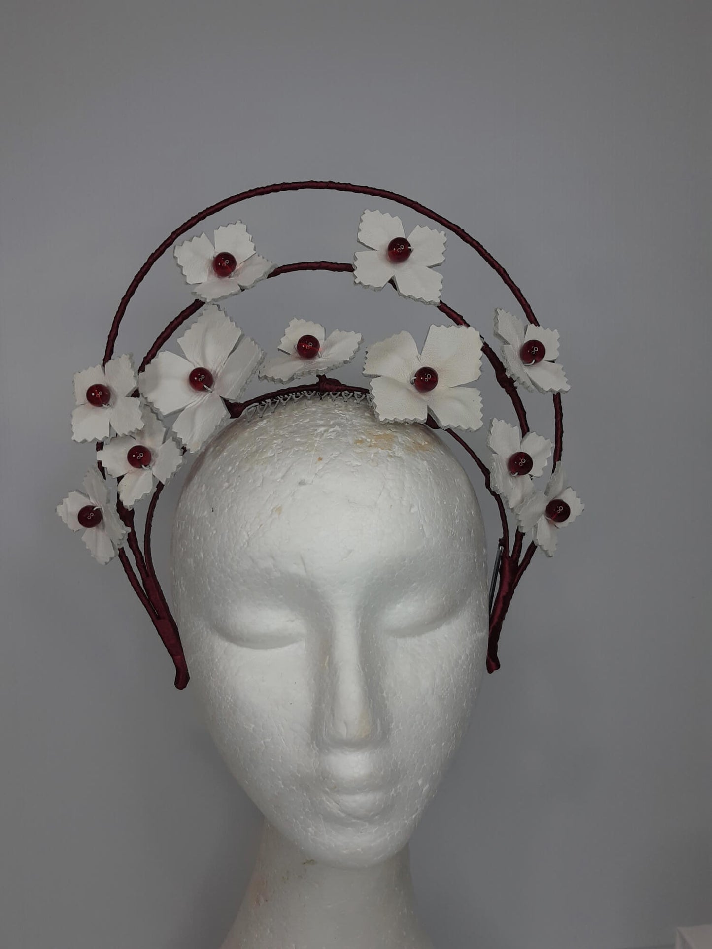 A picture of a Red and White Leather Millinery Halo Crown by Melissa Rath Millinery.