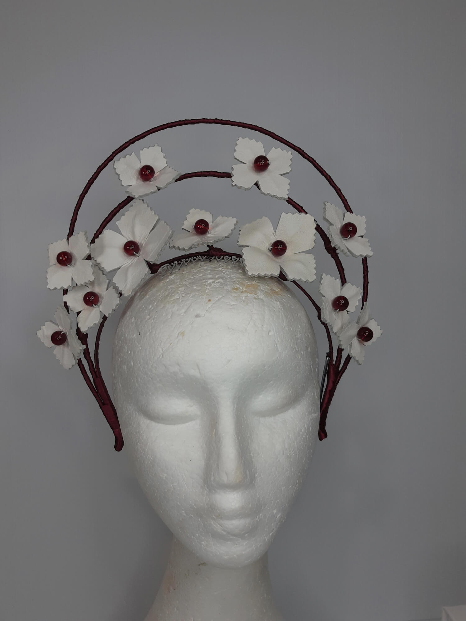 A picture of a Red and White Leather Millinery Halo Crown by Melissa Rath Millinery.
