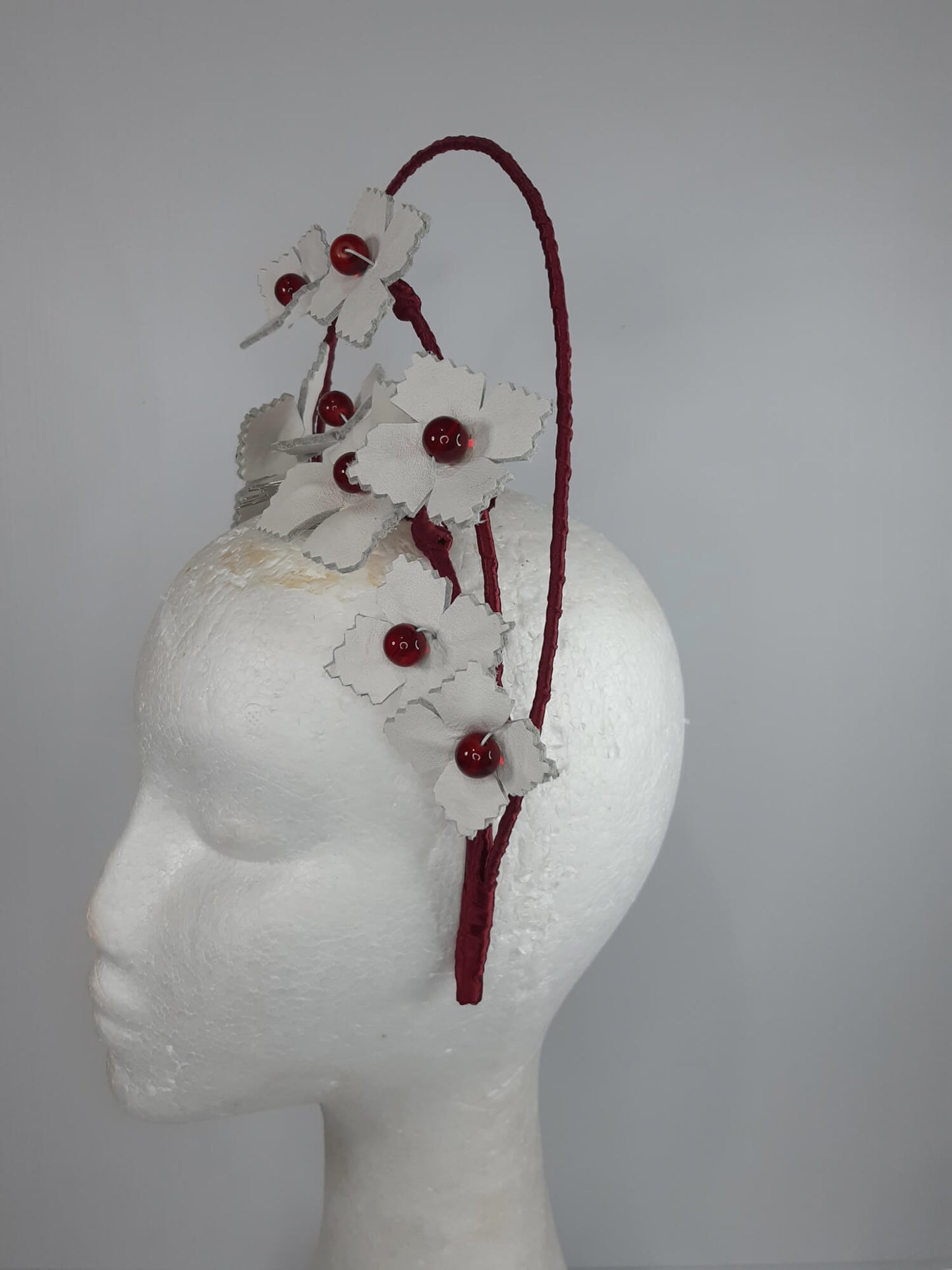 A picture of a Red and White Leather Millinery Halo Crown by Melissa Rath Millinery.