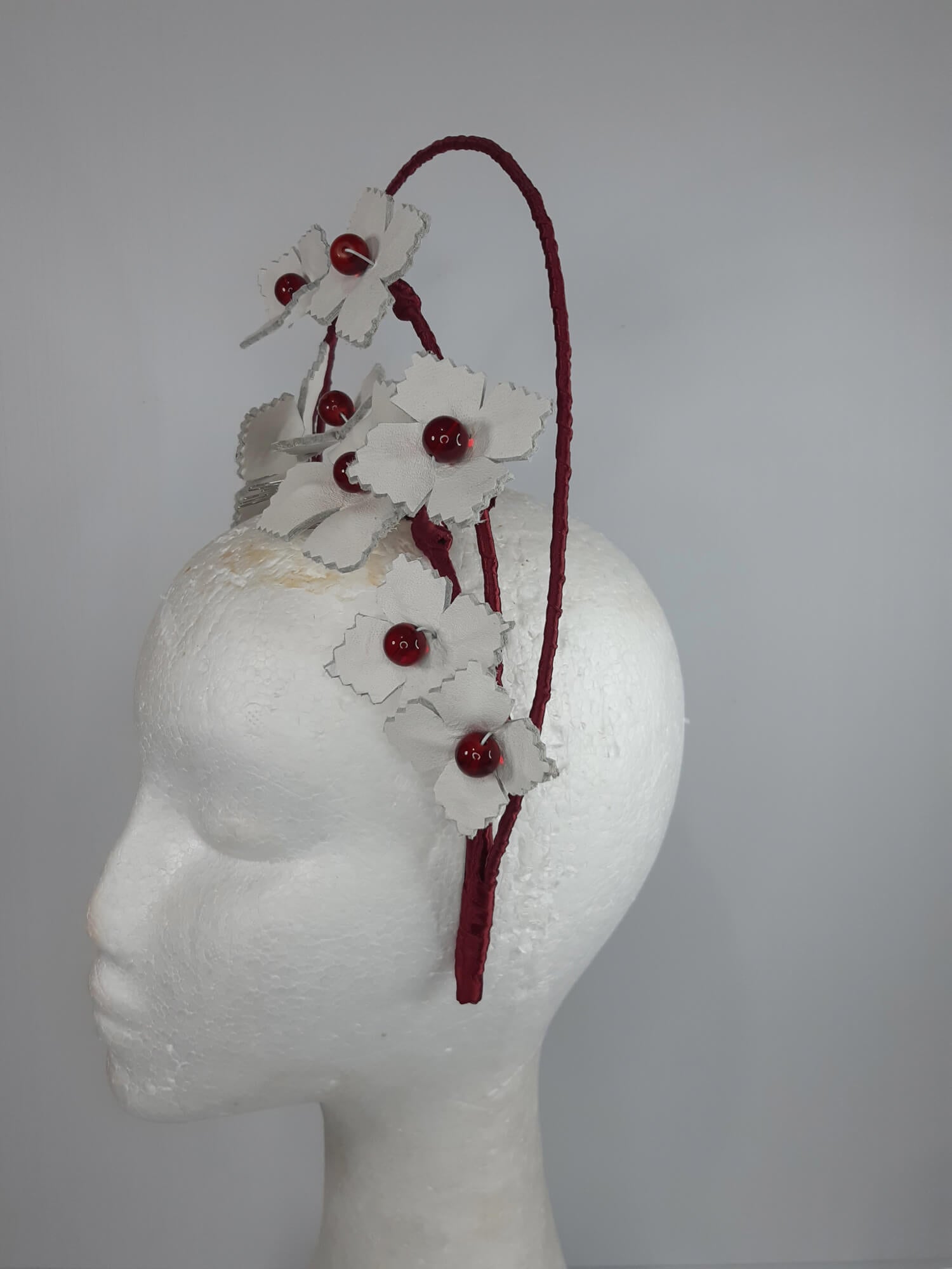A picture of a Red and White Leather Millinery Halo Crown by Melissa Rath Millinery.